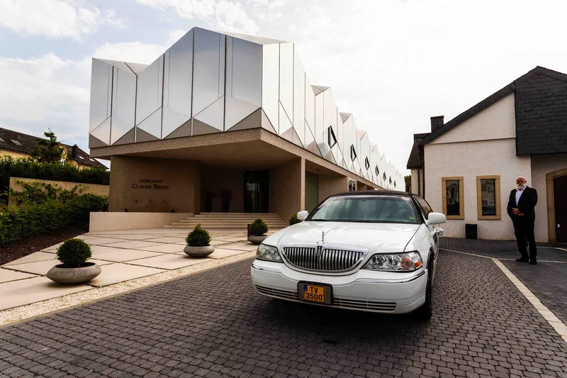 Arrivée en limousine blanche devant un domaine viticole contemporain.