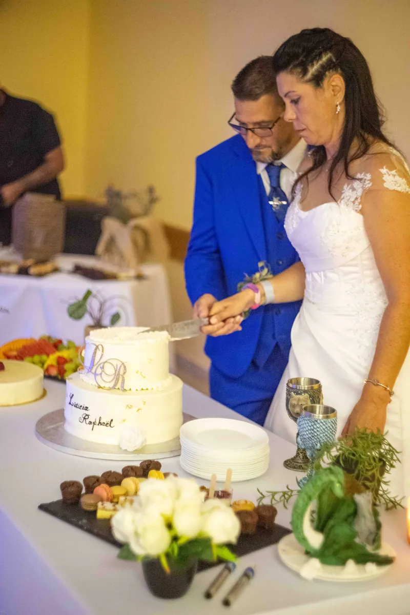 Les mariés coupent ensemble le gâteau.