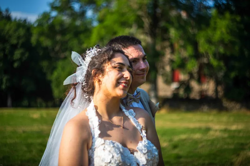 Éclat de rire de la mariée contre l’épaule du marié.