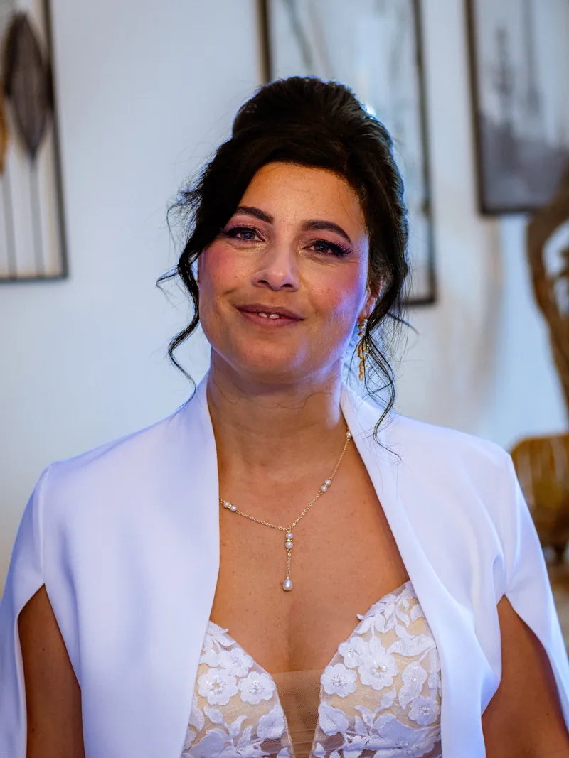 Portrait de la mariée souriante, juste avant de partir à la mairie.