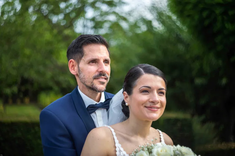 Portrait souriant des mariés dans la verdure.