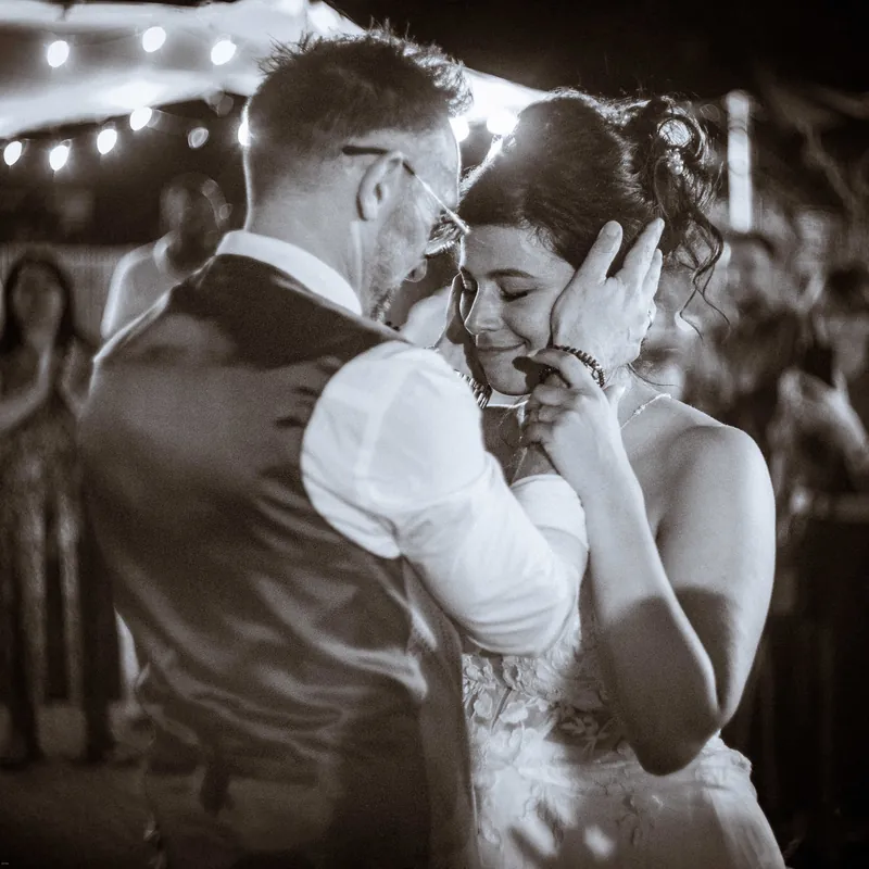 Première danse en noir et blanc, la mariée blottie contre le marié.
