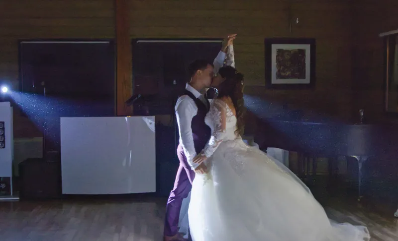Première danse des mariés dans une salle aux lumières tamisées.
