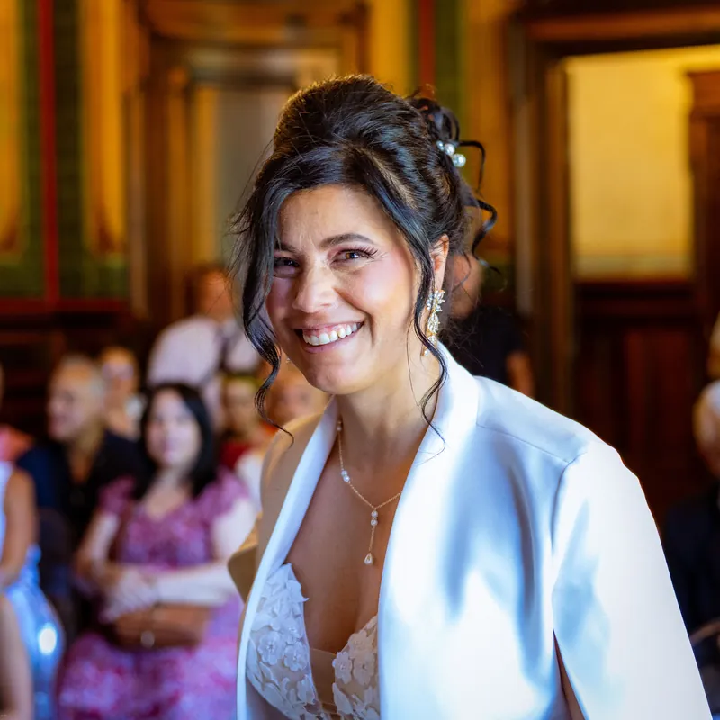 Éclat de rire de la mariée dans la salle des mariages aux boiseries dorées.