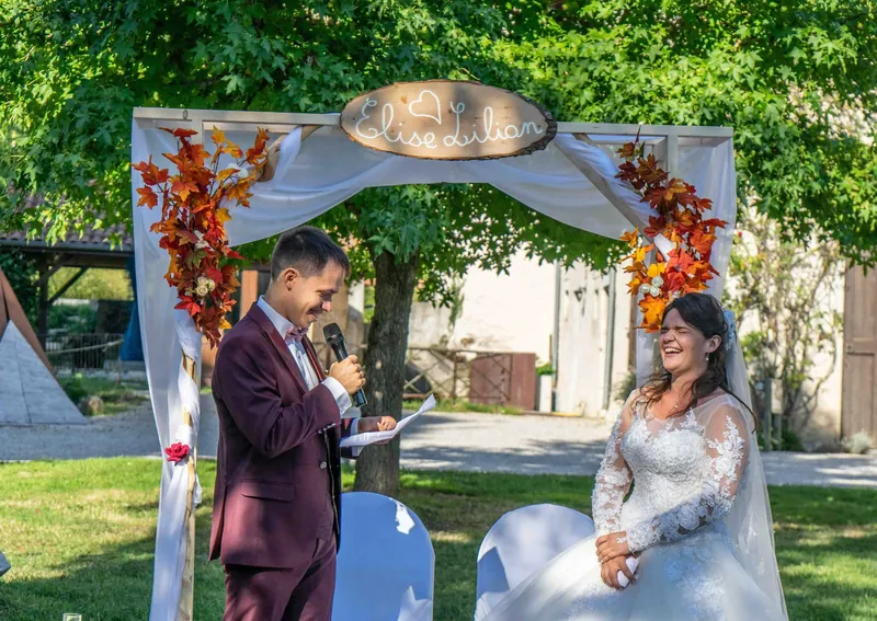 Le marié lit ses vœux sous l’arche, la mariée l’écoute.